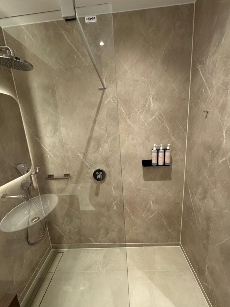 Inloopdouche in hotel met Aqua Composite Panels in Marble Beige