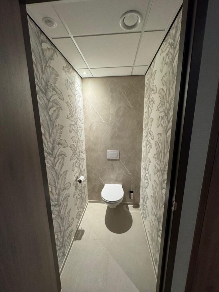 Hoteltoilet met Aqua Composite Panels in Marble Beige en een marmerdecor