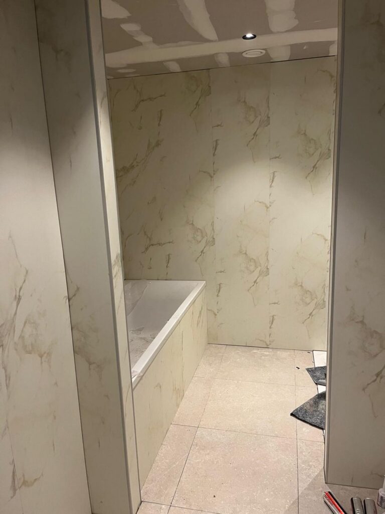 Hotelbadkamer tijdens de montage van Aqua Composite Panels in Marmo Oro
